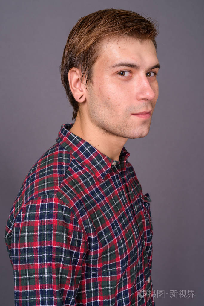 灰色背景下的年轻帅哥的肖像
