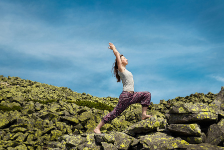 女人做瑜伽运动对新鲜空气与蓝蓝的天空上酒泉