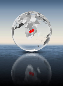 赞比亚在红色在透明地球漂浮在水之上。3d 插图