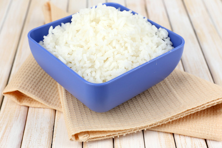煮熟的米饭在碗上木制的背景