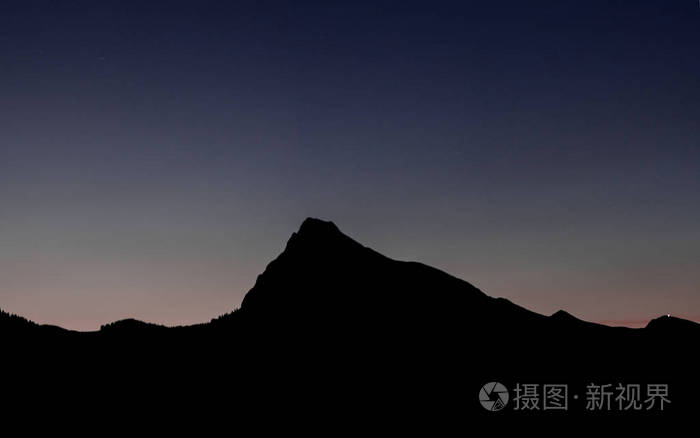 日落后傍晚天空下的山景剪影