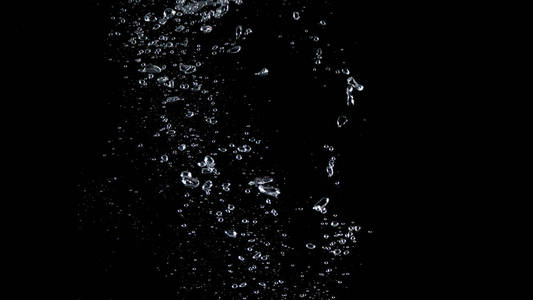 水气泡漂浮在黑色背景上,代表了苏打水或碳酸饮料的提神剂,以及液体的