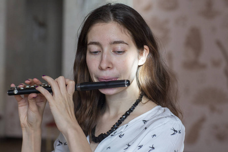 一个华丽的年轻女子坐在一起玩长笛短笛特写照片