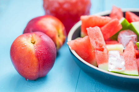 桃子冰蓝色背景下的冰桃和桃子片中的西瓜切片特写照片