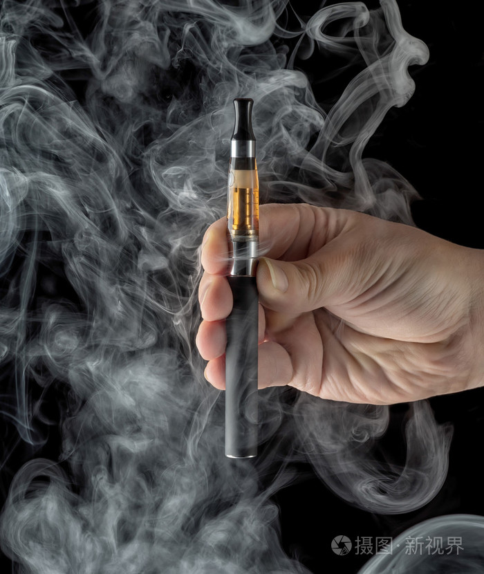 手拿着深色背景上的一种电子香烟
