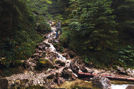 年轻妇女旅行者在茂密的森林与山河。旅游生活方式