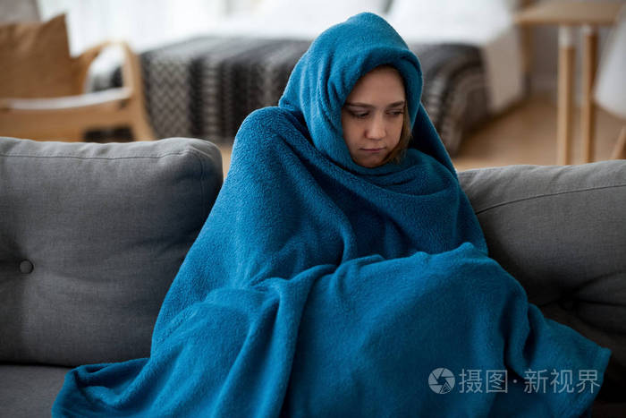 在家里女人感觉冷被温暖的毯子覆盖着