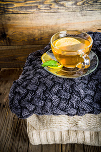 秋天的舒适和温馨的概念。茶玻璃杯配以柠檬薄荷和香料, 在古老质朴的木质背景上保暖毯。复制文本空间