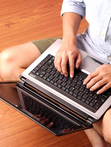 一个人坐在笔记本电脑上打字的特写镜头