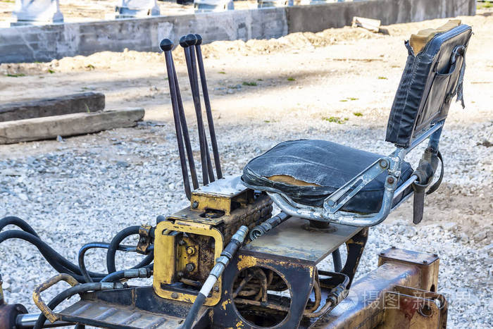 在露天的拖拉机上工作的拖拉机司机.一辆旧拖拉机