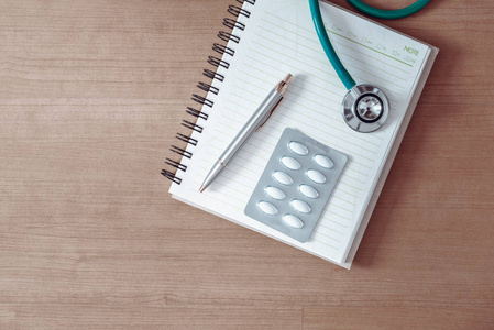 健康检查的概念, 医生的表工作区与听诊器和笔记本的顶部视图