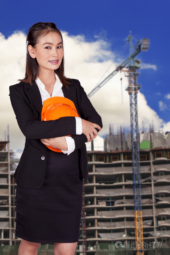 工程师女人手里拿着一个橘黄色的头盔