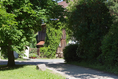 在6月的一个非常阳光明媚的一天, 在德国南部, 你看到农村的房子和门面与树木和植物周围的小村庄和地方