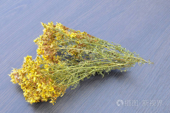 圣约翰草的干草对背景的灰色木质背景