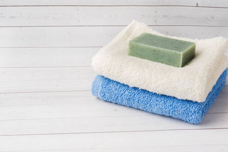 白色背景的水疗和健康概念。毛巾奶油肥皂和洗浴用品复制空间
