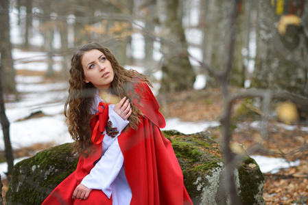 美丽的女人，与红色的斗篷，在树林里摆姿势