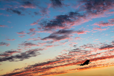五颜六色的明亮的日落与飞行飞机剪影