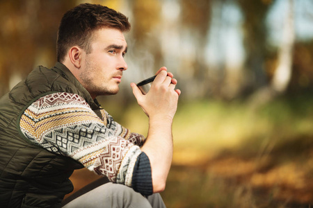 一个英俊的男人坐在大自然里喝茶.自由, 生活方式, 秋季照片