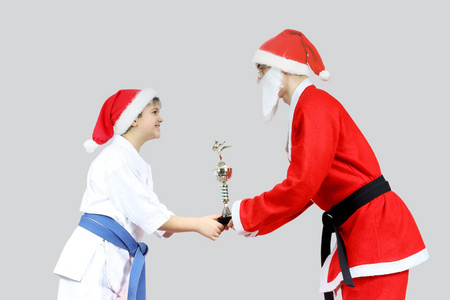 在 karategi 的运动员从圣诞老人那里接收与黑带空手道杯