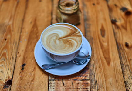 一杯咖啡在一个木制背景上的白色杯