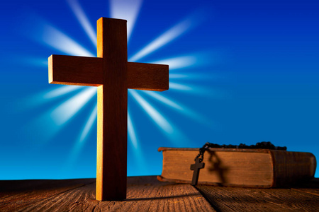基督教木十字架蓝色天空木制与圣经和念珠珠照片