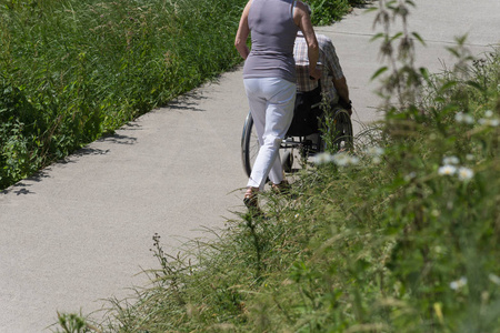 在一个非常晴朗的一天, 在6月在德国南部, 你看到单身女士推助行车在绿色公园散步