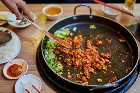 韩国辣泡菜烧烤猪肉在一个热锅与边菜和大米为背景