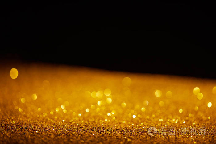 黑色背景下的金色发光闪光模糊