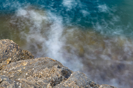 在希腊的爱琴海岸，萨索斯岛岛屿波和岩石长时间曝光摄影
