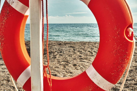 救生圈帮助下沉的人明亮的橙色在海边度假胜地海边的水上安装在一个特殊的柱子上。