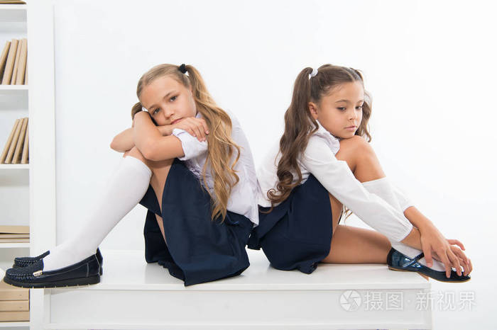 在学校里侮辱两个小女孩的孩子或姐妹.穿校服的小女孩