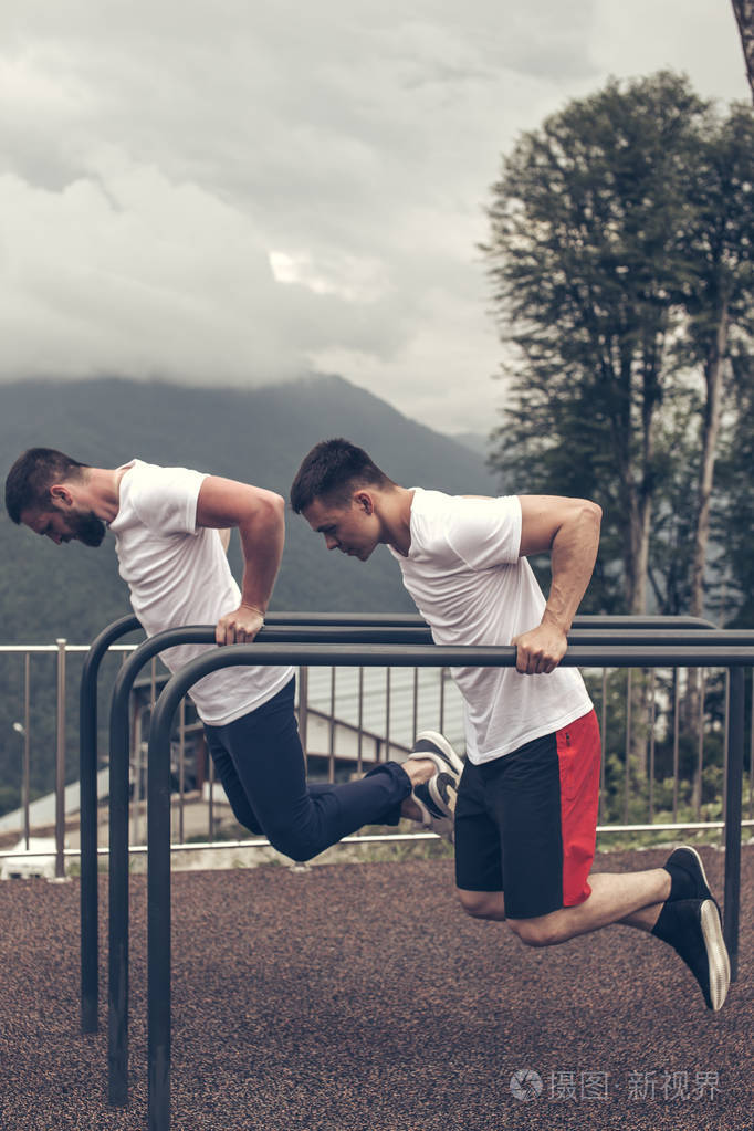 两个运动员在双杠上做浸渍