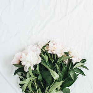 平躺, 顶上的白色牡丹花花束在白色毯子背景。最小夏季花卉概念