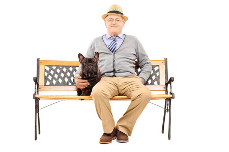 在与他的狗的长椅上的老绅士