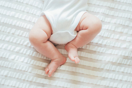 婴儿的脚躺在白色的床单上图片