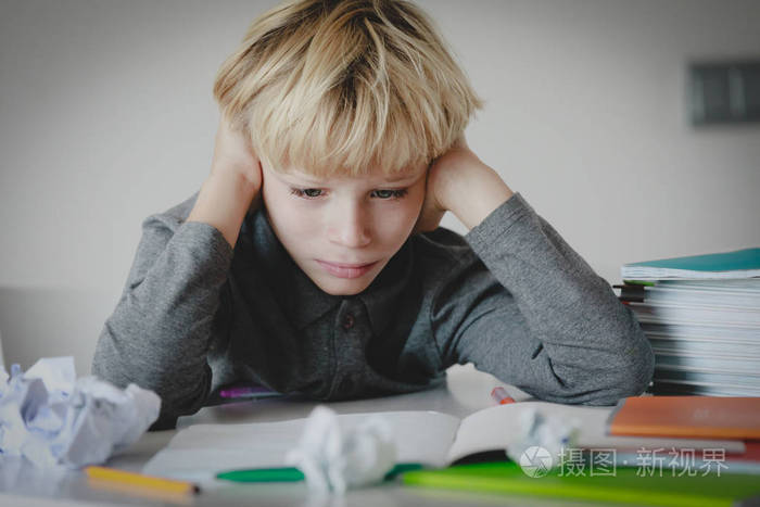 小男孩疲劳地看书, 做作业