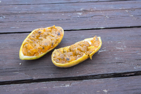 香蕉西番莲和柠檬西番莲水果在木桌上, 一半水果准备吃, 水果果肉种子