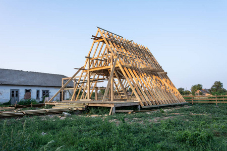 木结构住宅建筑在建。新住宅建筑房屋在日落时对蓝天的构筑