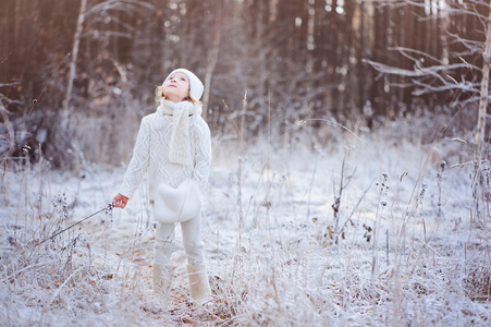 可爱的快乐儿童女孩走在下雪的冬天森林