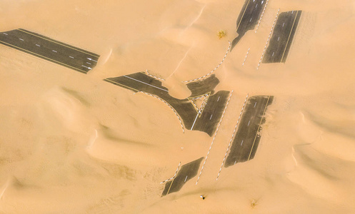 迪拜附近沙漠中的沙子覆盖的道路
