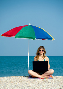 笔记本电脑在海滩上的女孩