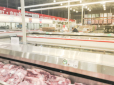 美国批发店模糊的抽象肉类部门。从巨大的开放式冰箱购买新鲜生牛肉鸡肉海鲜的客户购物