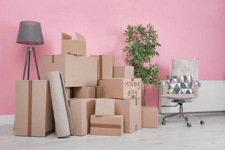 纸板箱和家庭用品在空房间。搬家日