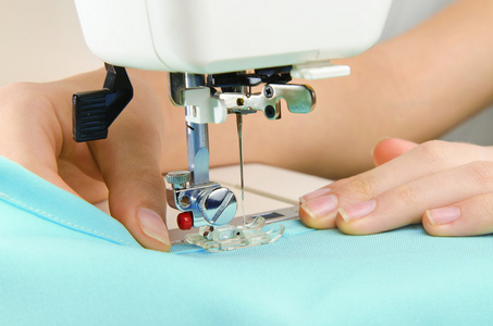 形象的女裁缝在缝纫机上工作照片