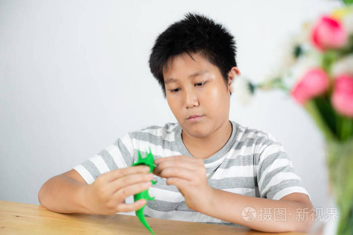 快乐亚洲青春期男孩在家玩面团