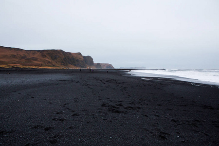 冰岛南部海岸的维克附近的黑色沙滩的形象。冰岛南部黑色熔岩海滩上的白色泡沫。冰岛的景点和自然风光