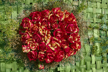 红黄玫瑰花在绿色背景。花卉背景。顶部视图