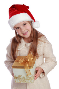 美丽微笑的小女孩，在圣诞老人的红帽子捧着圣诞的盒子