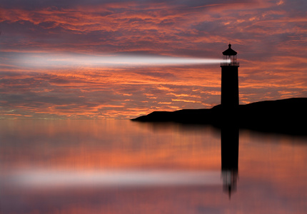 灯塔探照灯光束通过夜间的海洋空气照片