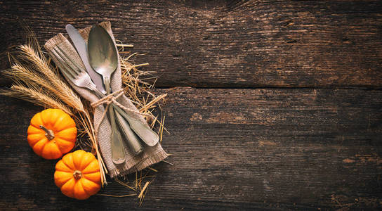 秋季背景从南瓜和小麦与复古的地方设置在老木桌。感恩节概念